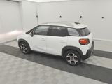 the back of a white car is parked in a garage