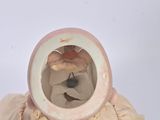 a small vase that has a teddy bear inside of it