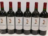 six bottles of red wine are lined up on a table