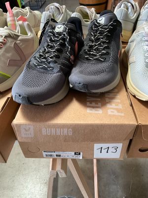 several pairs of running shoes are on a box in a store