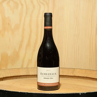 a bottle of wine sitting on top of a barrel