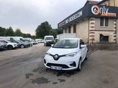 a white car parked in front of a building in a parking lot