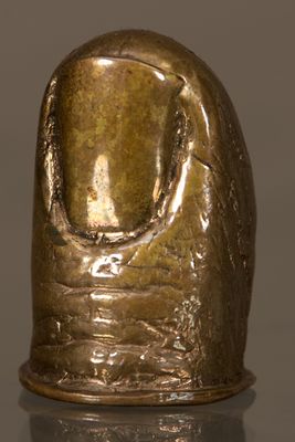 une figurine en bronze représentant la tête d'une femme posée sur une surface réfléchissante