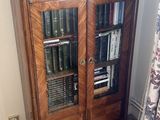 a cabinet with books on top of it in the corner of a room