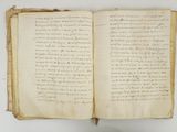 an old open book with writing on it sitting on a table