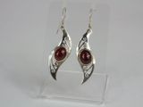 silver and red stone earrings on display in a clear acrylic holder