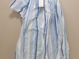 blue and white striped dress hanging on a hanger against a wall