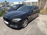 bmw 5 series saloone in black parked in a parking lot