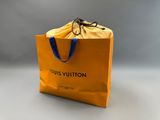 un gros plan sur un sac jaune muni d'une anse bleue