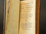 an old book opened to reveal a page of text on a black surface