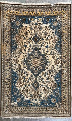 un tapis bleu et beige orné d'un motif en médaillon
