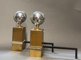 pair of polished steel and brass spheres on pedestals on a white background
