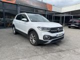 a white volkswagen suv parked in front of a building