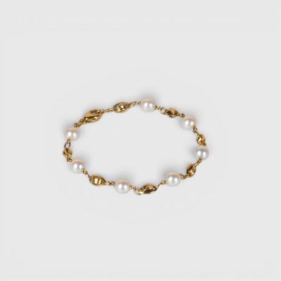 un bracelet en or orné de perles sur fond blanc