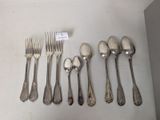 five forks and six spoons on the table