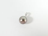 a close up of a pearl pendant on a white surface