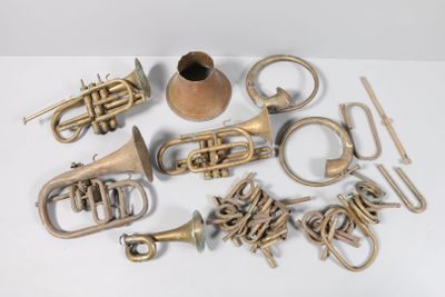a lot of brass musical instruments on a white surface