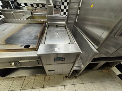 a large stainless steel oven in a kitchen with a checkered floor