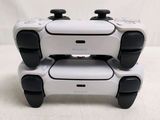 two white controllers sitting on top of each other on top of a table