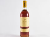 an old bottle of wine sitting on a white surface