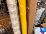 a stack of boxes and a roll of plastic on the floor