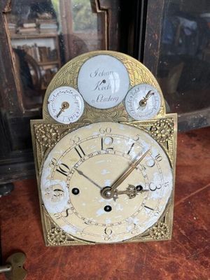 une horloge posée sur une table devant un miroir