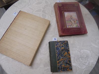 trois livres posés sur une table recouverte d'une nappe blanche