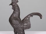 a black rooster statue sitting on top of a white table