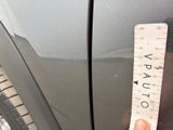 a hand holding a ruler that is on the side of a car