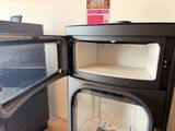 two open refrigerators sitting next to each other on the floor