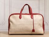 un sac rouge et beige posé sur un parquet