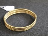 un gros plan sur une paire de bracelets en fil métallique de couleur dorée posés sur une table