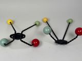 three different colored beads attached to a hook on a white surface