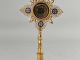 a gold cross with a blue and white clock on it