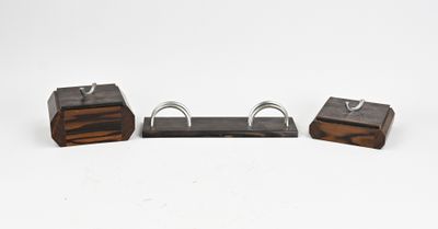 trois morceaux de bois et de métal sont posés sur une surface blanche