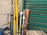 a stack of pallets and other items in front of a green garage door