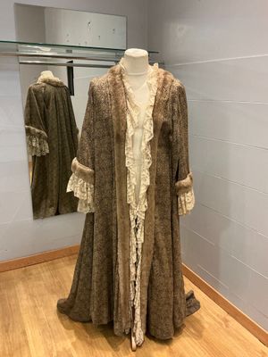un mannequin dans un coin de la pièce, vêtu d'un manteau