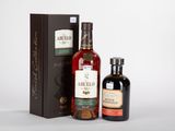 deux bouteilles de whisky et une boîte de spiritueux sur fond blanc