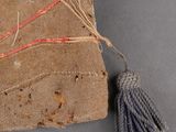 an old book with a tassel on top of it