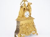 a gold clock that is sitting on top of a table