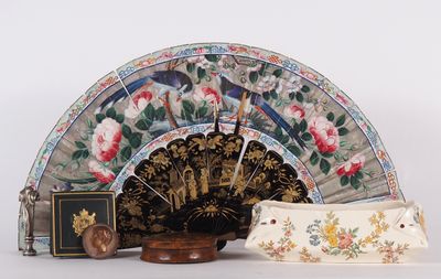 a fan, a purse, and a book sitting on a table