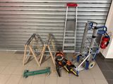 many tools that are sitting on the floor in front of a garage door