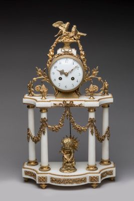 a white and gold clock sitting on top of a table