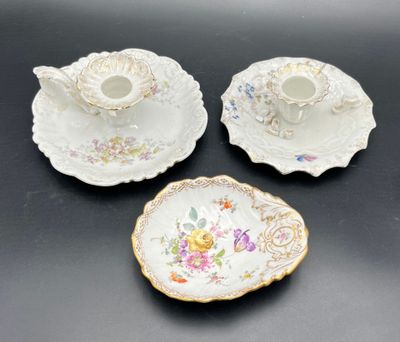 three pieces of porcelain with floral designs on them on a table
