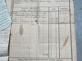 some old papers are sitting on a table with a pen and paper