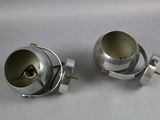 two silver metal objects sitting on a white surface