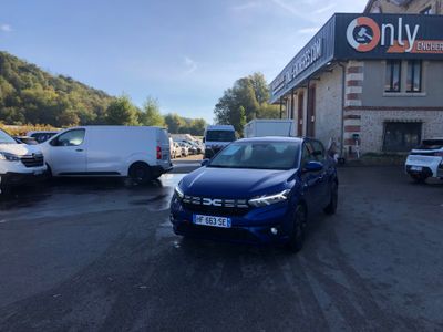 La voiture bleue est garée devant l'immeuble, sur le parking.