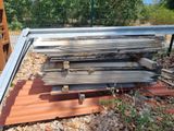 a pile of wood sitting on the ground next to a fence