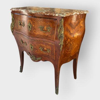 an antique chest of drawers with a marble top on a stand