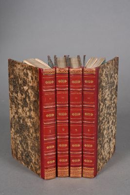 three books are stacked on top of each other on a gray surface
